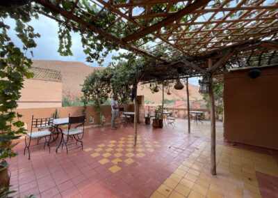 Shared guest house terrace beneath a pergola